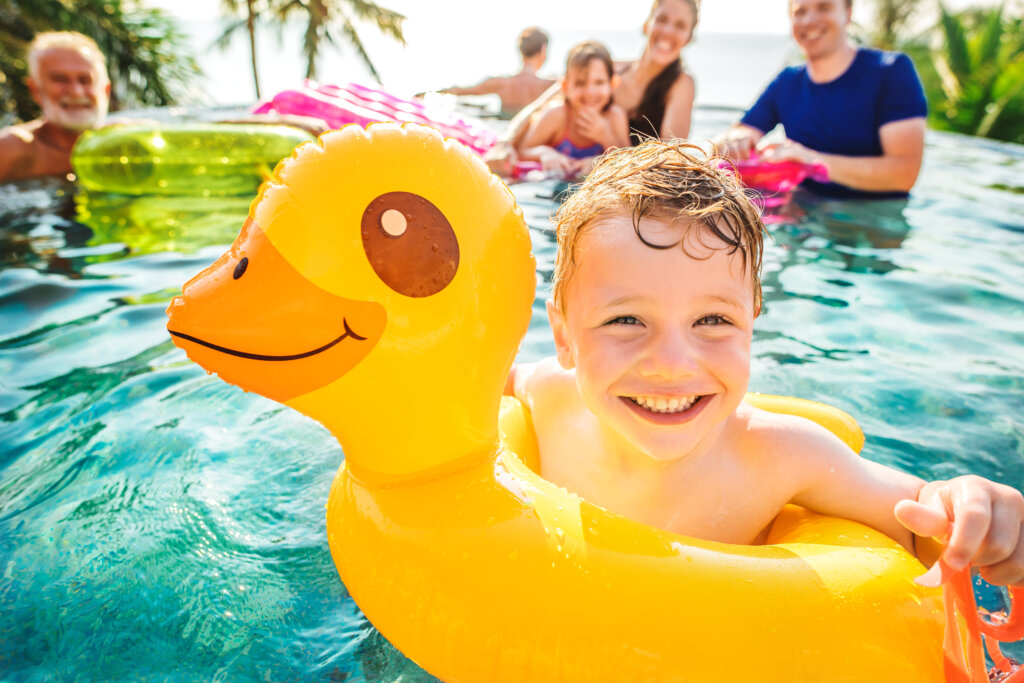 Boy swimming in a pool with family